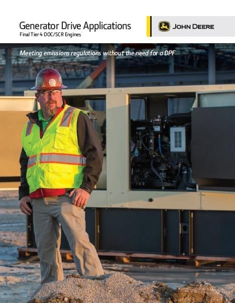 A person wearing a safety vest and a hard hat near a generator at dawn.